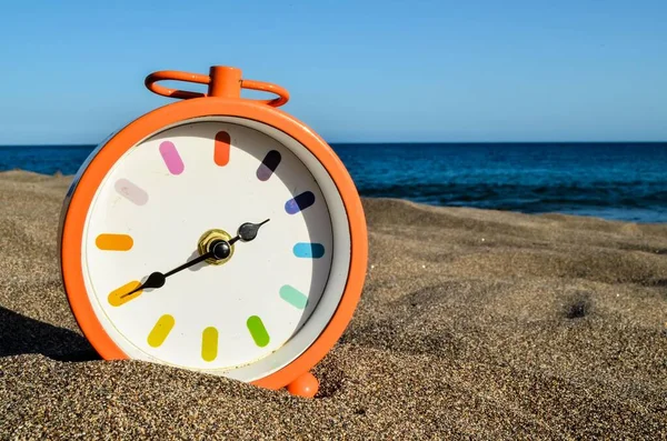 time to travel concept. sand beach with clock on sandy seashore