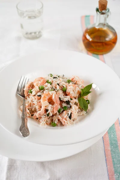 Rice with shrimps, fish, green peas, and mint Stock Photo