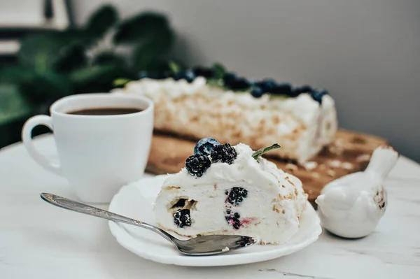 a piece of cake with cream and berries