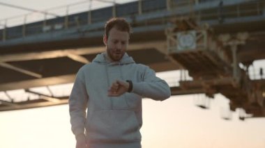 Erkek sporcu dışarıda koşarken spor takip cihazı kullanıyor