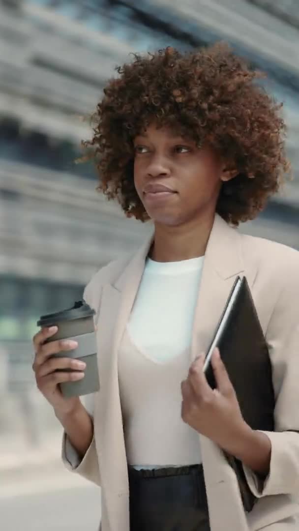 Femme afro-américaine marchant dans la rue avec du café et des fichiers dossier — Video