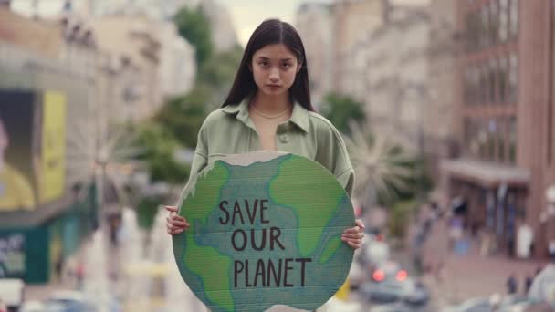 Asijské žena držení zachránit naši planetu prapor na ulici — Stock video