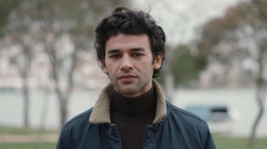 Dışarıdaki sakin suratlı Arap adam kameraya bakıyor.