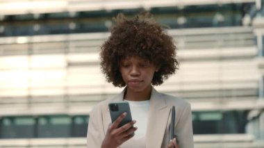 İş kadını cep telefonunda iyi haberler okurken gülümsüyor