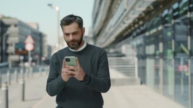 Açık havada cep telefonu kullanan kendinden emin bir iş adamı.