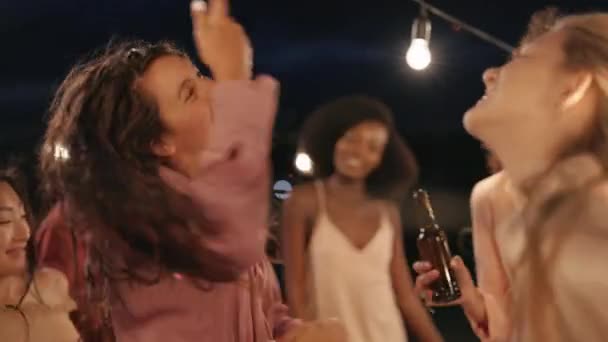 Alegre diversos amigos bailando juntos en la azotea por la noche — Vídeo de stock