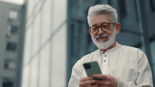 Volwassen man tevreden met goed nieuws op mobiele — Stockvideo