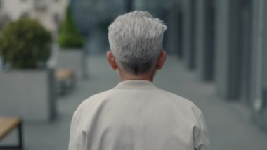 Son sınıf öğrencisi şık kıyafetler içinde sokakta yürürken.