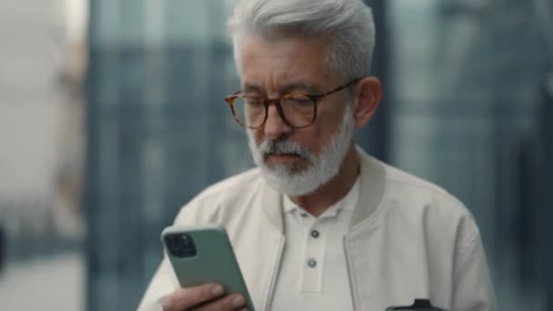 Starší muž s kávou a mobilní venku — Stock video