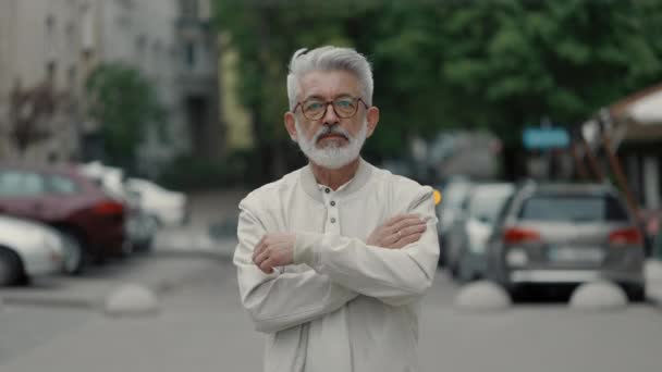 Starší muž držící ruce křížem, když stojí venku — Stock video
