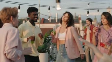 Genç çok ırklı insanlar yazın çatıda eğleniyor.