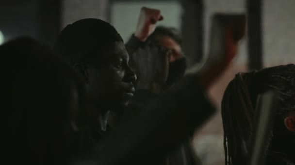 Львів, Україна - 3 червня 2020: Африканський американський бородатий чоловік, що піднімає стиснутий кулак. Молодий хлопець стоїть у натовпі протестувальників на нічній вулиці міста. Концепція страйку, прав людини і ні расизму. — стокове відео