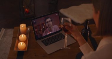 Kadın, erkek arkadaşıyla laptopta video görüşmesi yapıyor.