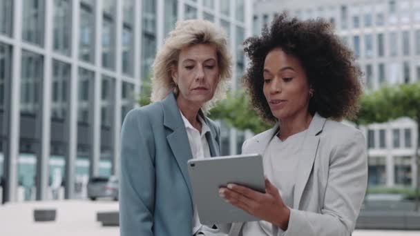 Diverses femmes utilisant une tablette pendant un discours d'affaires dans la rue — Video