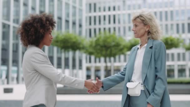 Multiracial business ladies shaking hände on street — Stockvideo