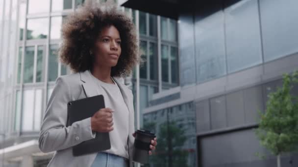 Mujer de negocios caminando por la calle con café y móvil — Vídeos de Stock