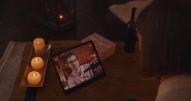 Sevgilisiyle online randevu için tablet kullanan bir kadın.