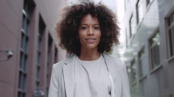 Afrikai amerikai nő öltönyben mosolyog a kamera előtt a szabadban — Stock videók