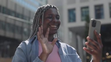 Afrikalı Amerikalı kadın cep telefonundan video görüşmesi yapıyor.