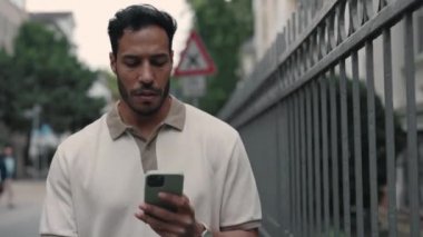 Sokakta yürürken cep telefonu kullanan Afrikalı Amerikalı.
