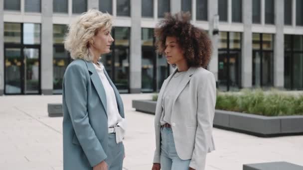 Дві багатокультурні бізнес-леді позують на міській вулиці — стокове відео