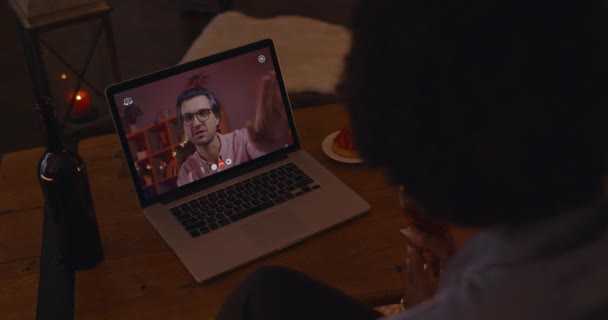 Pareja de raza mixta utilizando el ordenador portátil para citas en línea en casa — Vídeos de Stock