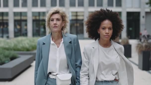 Dos mujeres de negocios diversas caminando al aire libre — Vídeo de stock