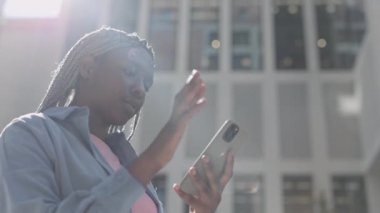 Afro-Amerikalı kadın akıllı telefondan iyi haberler alıyor.