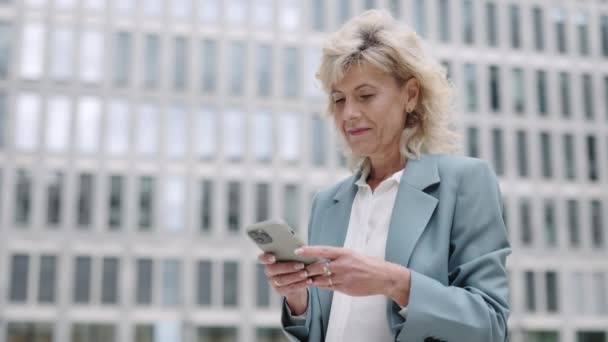 Mujer de negocios haciendo gestos durante las buenas noticias en el móvil — Vídeos de Stock