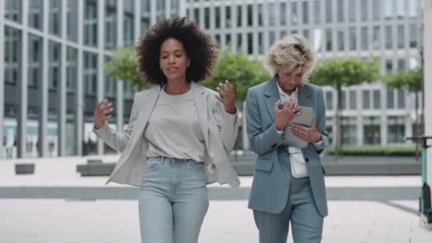 Duas mulheres de negócios deprimidas conversando e gesticulando na rua — Vídeo de Stock