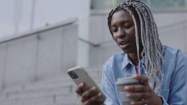Afroamerikanska kvinnan använda mobiltelefon utomhus — Stockvideo