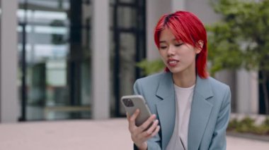 Dışarıdaki akıllı telefondan görüntülü arama yapan Asyalı kadın.