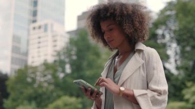 Mobil açık hava kullanan şık bir Afro-Amerikan kadını.