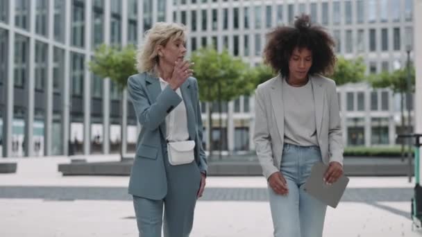 Upset business ladies walking with tablet on street — 图库视频影像