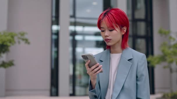 Asian woman standing on street and using smartphone — Stock Video