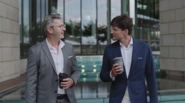 İş ortakları şehir sokaklarında yürüyüp konuşuyor.