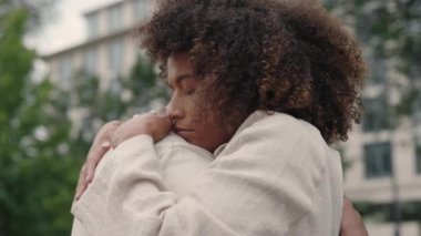 Gözleri kapalı bir kadın, şehir caddesinde erkekleri kucaklıyor.