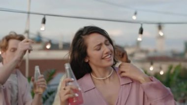 Beyaz kadın dans ediyor ve melez ırk arkadaşlarıyla içiyor.