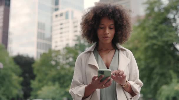 Mujer afroamericana usando smartphone en la calle de la ciudad — Vídeo de stock