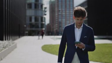 İş adamı yürürken cep telefonundan iyi haberler alıyor