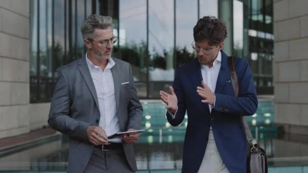 Les hommes d'affaires utilisant la tablette et bavarder tout en marchant — Video