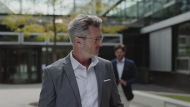 Patron imzalarken elinde belgelerle pano tutan adam.