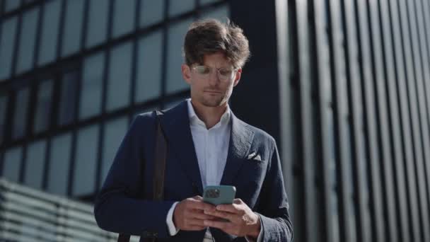 Businessman standing on street and using smartphone — Stock Video