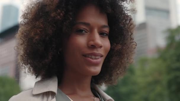 Afrikansk-amerikansk kvinne står på gata og smiler – stockvideo