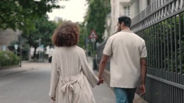 Afrikalı Amerikalı çift sokakta sarılıp yürüyorlar.