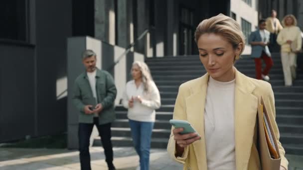 Business woman using smartphone near office building — Stock videók