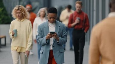 Sokakta cep telefonu kullanan Afrikalı Amerikalı iş kadını