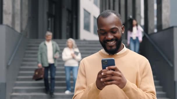 Afrikai-amerikai üzletember jó híreket olvas a mobil — Stock videók