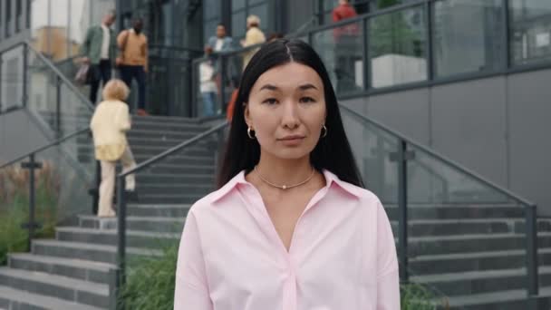 Portrait of asian business woman posing near office center — Stock video