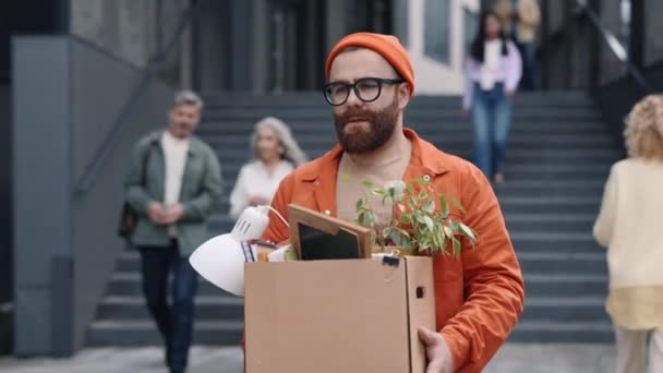 Man walking near business center with box of personal stuff — стоковое видео